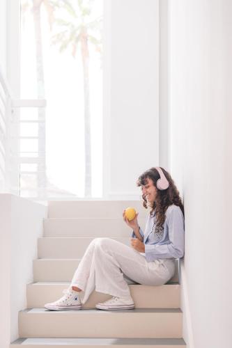 a woman sitting on the stairs holding an apple at So' Lifestyle Hotel Sorrento in Sorrento