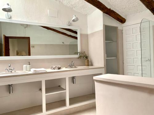 a white bathroom with a sink and a mirror at Els Racons del Fort Castle hosting up to 18 people in Capmany