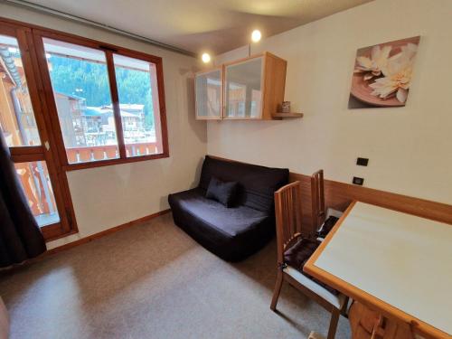 un salon avec un canapé noir et une table dans l'établissement Charmant studio cabine 4/5 pers, balcon, proche pistes et commerces à Modane - FR-1-265-189, à Valfréjus