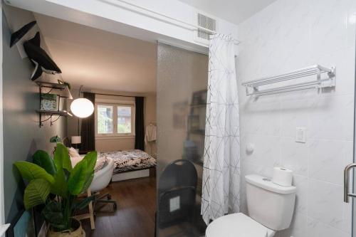 a bathroom with a toilet and a bedroom with a bed at Spacious Room with Ensuite Bathroom near Subway, Koreatown & UofT in Toronto