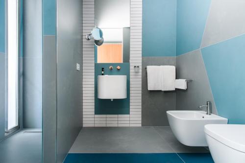 a bathroom with a white toilet and a sink at So' Lifestyle Hotel Sorrento in Sorrento