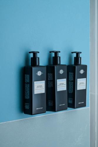 three bottles of soap sitting on a shelf at So' Lifestyle Hotel Sorrento in Sorrento