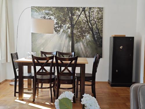 a dining room table with chairs and a painting on the wall at Hotel garni Königslinde - Wandern, Radeln, Skifahren & Genießen in Bayrischzell