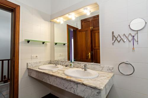 ein Badezimmer mit zwei Waschbecken und einem Spiegel in der Unterkunft 4BR Yaiza Relax House - Terrace & Mountain in Yaiza