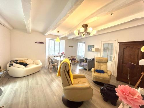 un salon avec un canapé, des chaises et une table dans l'établissement Bienvenue Chez Bob dans le centre-ville de Vivonne, à Vivonne