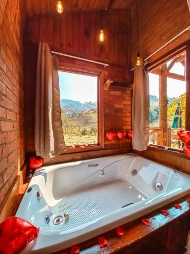 a bath tub in a room with a window at Chalés Refúgio no Campo in Santo Antônio do Pinhal