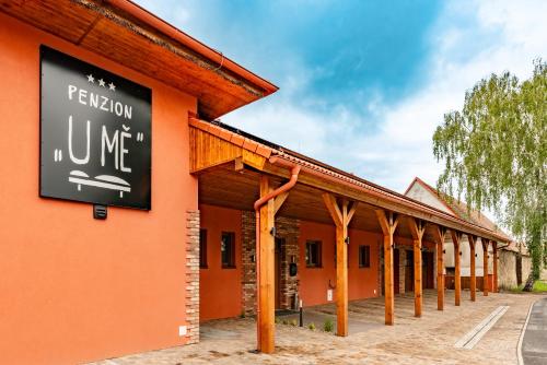 an orange building with a sign on the side of it at Penzion U Mě in Obora