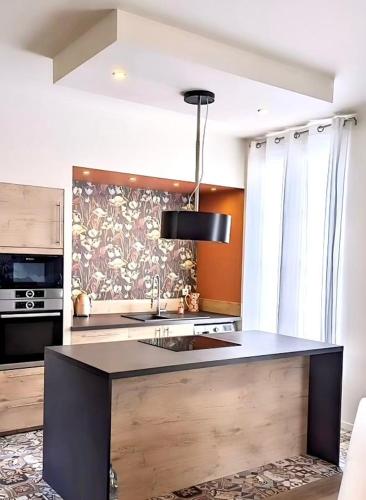 une cuisine avec un évier et une cuisinière four supérieur dans l'établissement La Lorraine : cosy en centre ville, à Poitiers