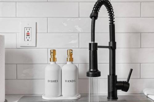 Dos botellas en una encimera de cocina junto a un grifo. en Charming Home in Cleveland 3215, en Ohio City