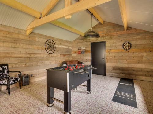 a ping pong table in a room with wooden walls at Vakantiehuis Bonne Home in Bree