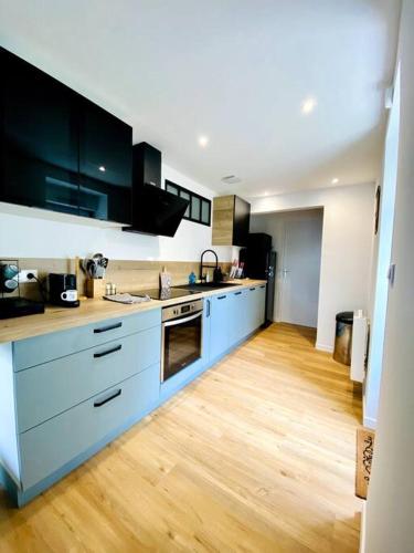 Il comprend une cuisine avec des placards bleus et du parquet. dans l'établissement Le Saint Maurice - Proche ville, à La Rochelle