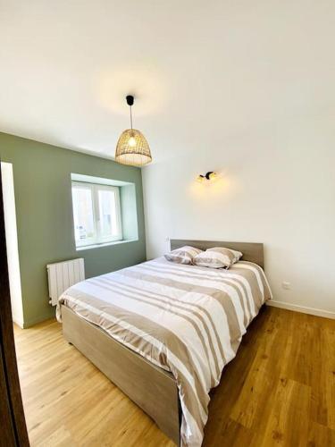 une chambre avec un lit avec deux oreillers dessus dans l'établissement Le Saint Maurice - Proche ville, à La Rochelle