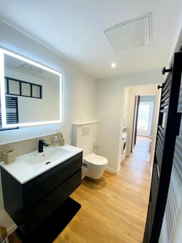 une salle de bain blanche avec un lavabo et des toilettes dans l'établissement Le Saint Maurice - Proche ville, à La Rochelle