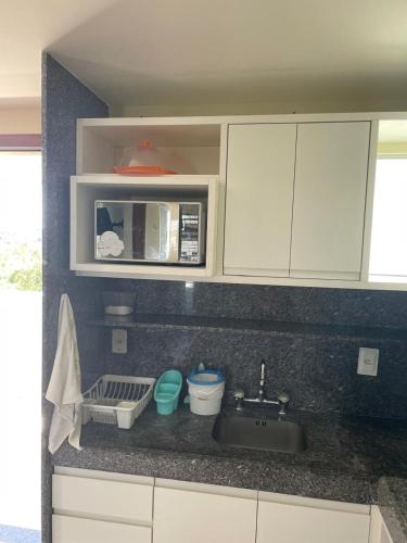 a kitchen counter with a sink and a microwave at Blue Marlin Resort&Spa in Parnamirim