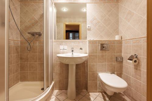 a bathroom with a sink and a toilet and a shower at Hotel Maltezský Kříž in Karlovy Vary