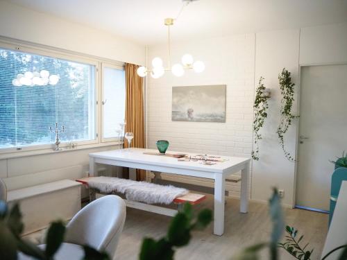 a living room with a white table and a window at Aurora Guest Room in Rovaniemi