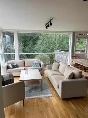 a living room with two couches and a table at En perle på Gjøvik, nær populær strand ved Mjøsa in Gjøvik