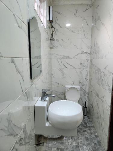 a white bathroom with a toilet and a sink at 2 bedroom Jab Villa in Adentan
