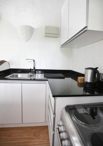 a kitchen with a sink and a stove at The Salty Palms in Beau Vallon