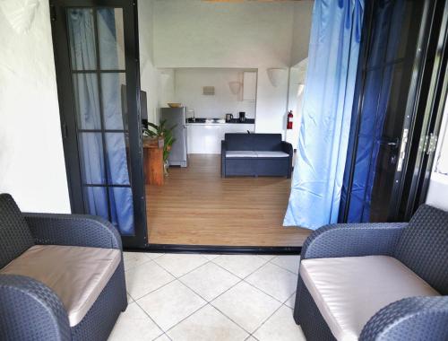 a living room with two couches and a kitchen at The Salty Palms in Beau Vallon