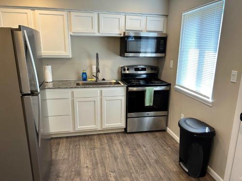 a kitchen with white cabinets and a stainless steel refrigerator at Carter #1 Two bedroom unit near Xavier Downtown in Cincinnati