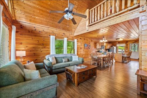 a living room with a couch and a ceiling fan at Misty Mountain Game Room and Hot Tub in Pigeon Forge