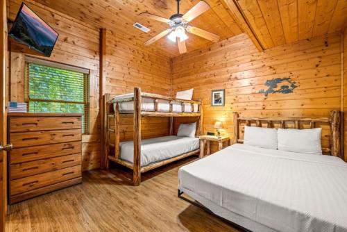 a bedroom with two bunk beds in a log cabin at Misty Mountain Game Room and Hot Tub in Pigeon Forge