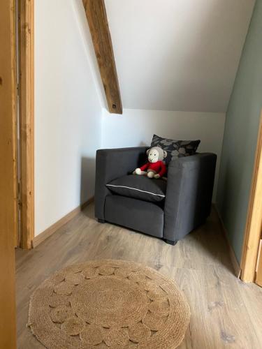 a teddy bear sitting on a couch in a room at A la campagne in Villers-Pol