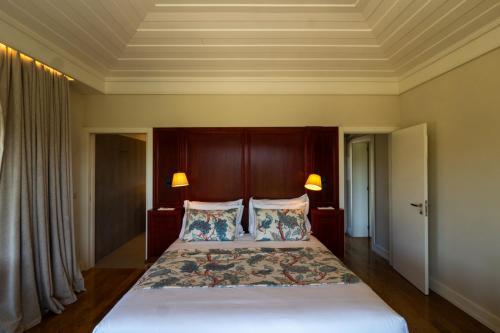 a bedroom with a large bed with two pillows at Quinta de Cypriano - Wine & Nature in Ponte da Barca