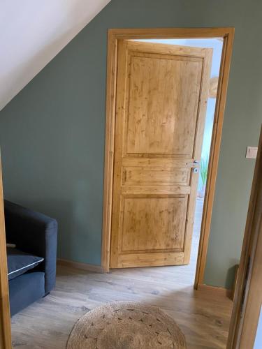 a wooden door in a room with a blue wall at A la campagne in Villers-Pol