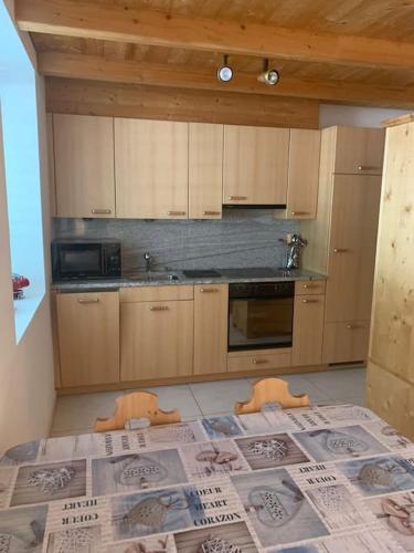 a kitchen with a bed with a newspaper on it at Comodo appartamento nel cuore dell'Engadina in Celerina