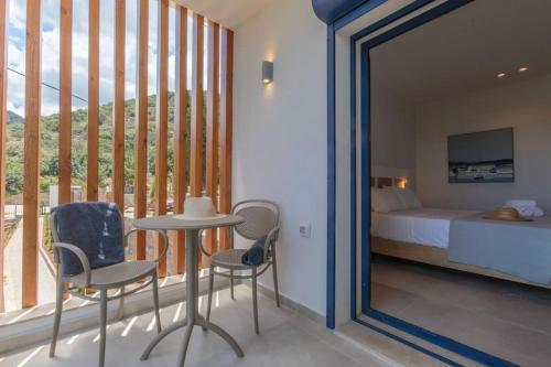 a bedroom with a mirror and a bed and a table and chairs at Thea Villa Santa Marina in Malia