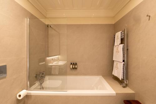 a bathroom with a bath tub and a sink at Quinta de Cypriano - Wine & Nature in Ponte da Barca