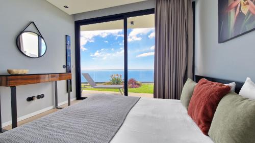 ein Schlafzimmer mit einem Bett mit Blick auf das Meer in der Unterkunft Villa Estrelícia by LovelyStay in Ribeira Brava