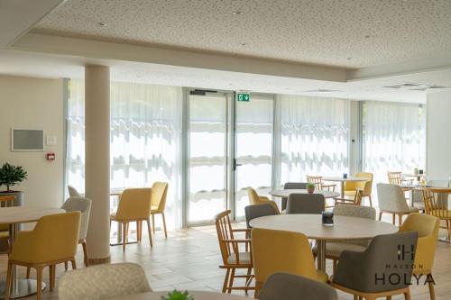 une salle à manger avec tables, chaises et fenêtres dans l'établissement Aux cœur de Limoges - Le Joli - 369B, à Limoges