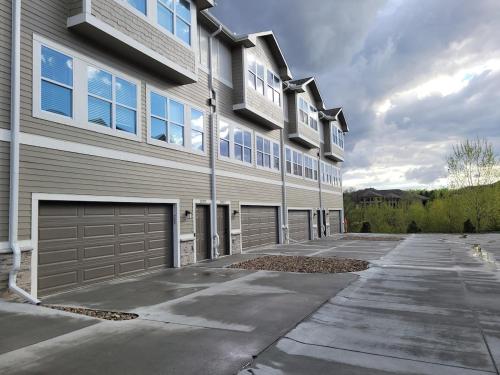 a large apartment building with a garage at The HoneyBee at Coventry Rows in Omaha