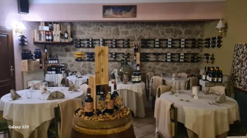 a restaurant with white tables and bottles of wine at Rocca Casa in Roccatederighi