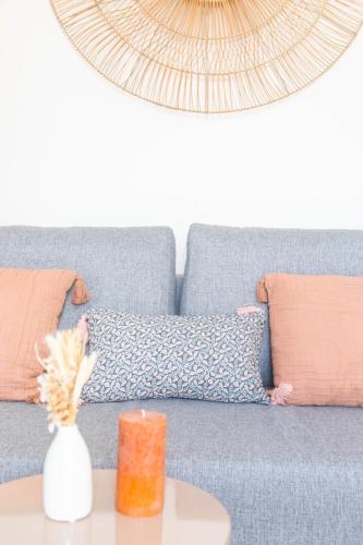 a blue couch with pillows and a vase on a table at L'Étoile - Tout confort in Drulingen