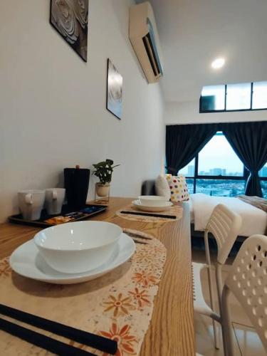 a kitchen with a table with white plates on it at Cozy Haven Superior Studio Free Private Parking Netflix in Petaling Jaya