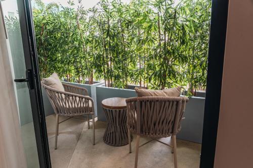 two chairs and a table on a balcony with trees at Wyndham Garden Mazatlan Marina in Mazatlán