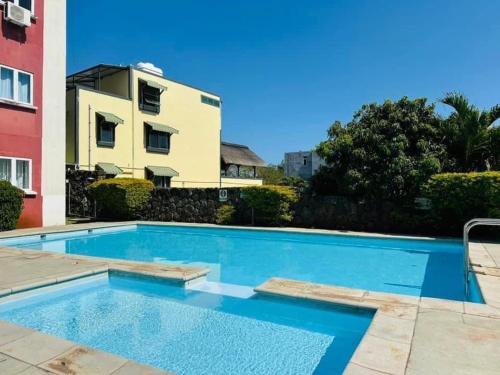 a swimming pool in front of a building at Appartement - A 300m de la mer in Pereybere