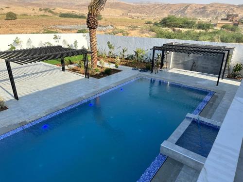 a large swimming pool in a yard with a palm tree at Venue in Al Rama