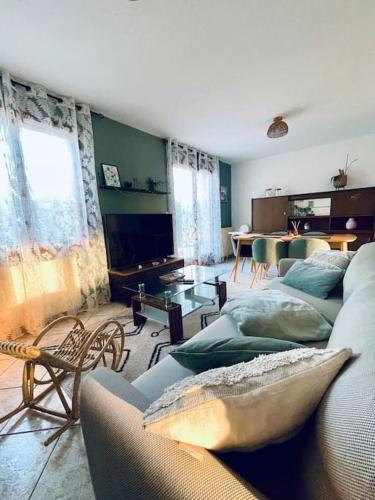 un salon avec deux canapés et une télévision dans l'établissement La P'tite Ambrièroise, à Ambrières