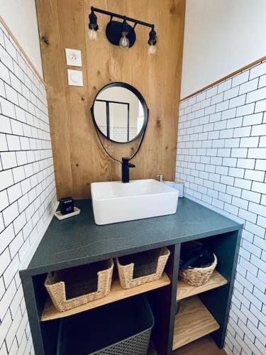 une salle de bain avec un lavabo et un miroir dans l'établissement La P'tite Ambrièroise, à Ambrières