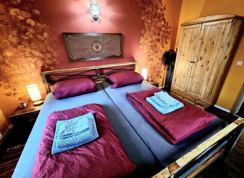 a bedroom with a large bed with purple sheets and pillows at Apartment im Mexiko-Stil in Niederneisen