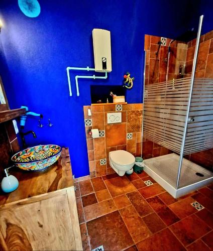 a blue bathroom with a toilet and a shower at Apartment im Mexiko-Stil in Niederneisen