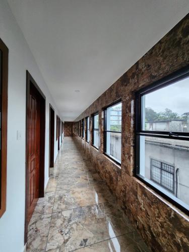 an empty corridor with windows in a building at Royal View Residency in Attingal