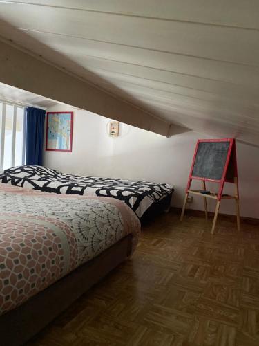 a bedroom with two beds and a chalkboard in it at Appartement vue mer in La Guérinière