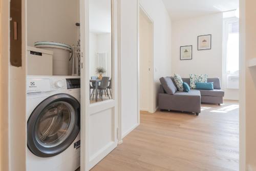 a living room with a washing machine and a couch at ManaraQuattro - apartament in Como near the center with free parking - Lake Como in Como