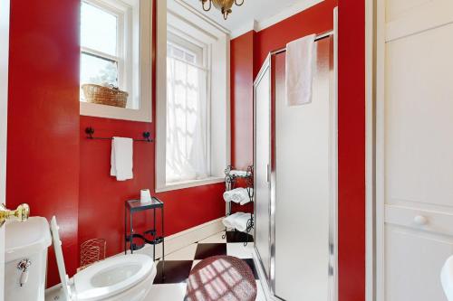 a red bathroom with a white toilet and a sink at North Star Manor in Waynesville